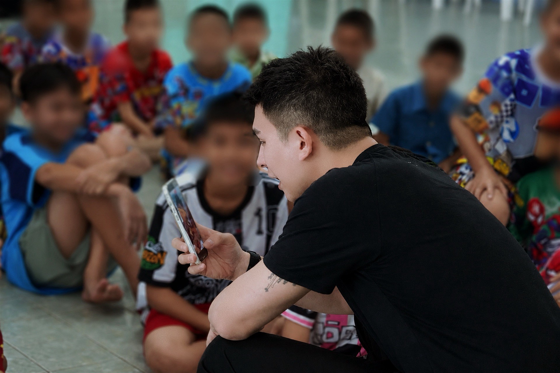 ช่วงนั่งล้อมวงพูดคุยและดูโทรศัพท์ร่วมกับน้อง ๆ ที่บ้านปากเกร็ด